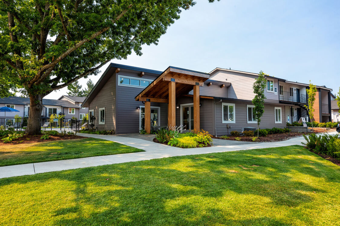 Building exterior with large trees and grassy sidewalk