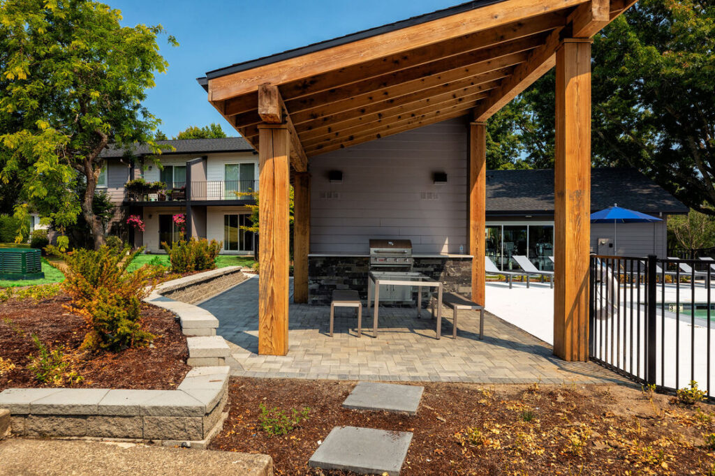 covered deck with grill next to the pool