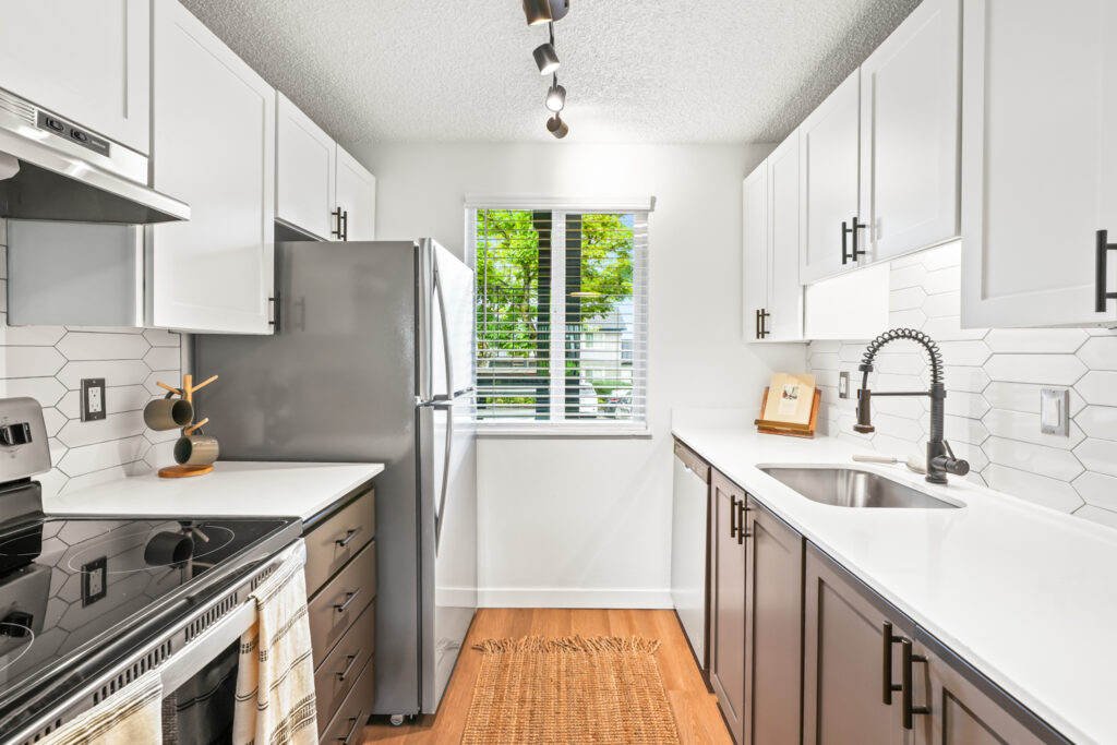 Kitchen with white counters and stainless steel appliances at The Alden apartments in Tualatin