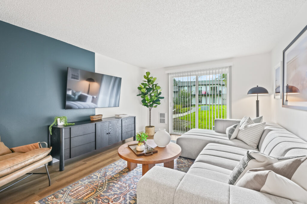 Living room with sliding glass doors at The Alden apartments in Tualatin
