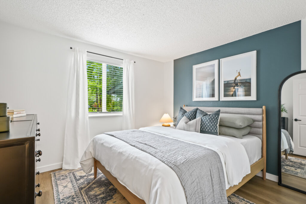 Bedroom with blue accent wall and large window